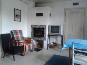 a living room with a fireplace and a television at Białka B in Białogóra