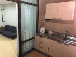 a kitchen with a sink and a couch in a room at De Junction House in Bang Kapi