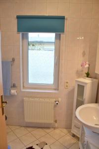 uma casa de banho com uma janela e um lavatório em Ferienhaus Leonie em Barth