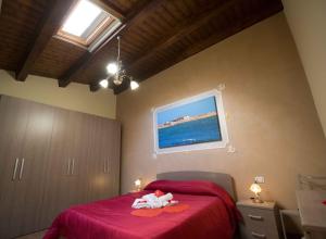 Schlafzimmer mit einem Bett mit roter Bettwäsche und einem Fenster in der Unterkunft Casa Aruci Sweet Home in Scicli