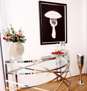 einen Glastisch mit einer Lampe und eine Vase mit Blumen in der Unterkunft Belle Epoque in Wien