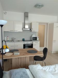 a kitchen with a wooden table and two chairs at Košice Smart Apartmán in Košice