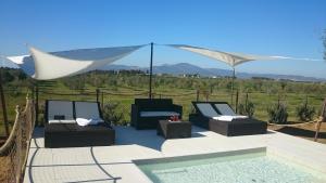 eine Terrasse mit Stühlen und einen Pool mit einem Zelt in der Unterkunft Azienda Agrituristica Le Betulle in Riotorto