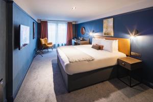a bedroom with a large bed and a large window at Seel Street Hotel by EPIC in Liverpool