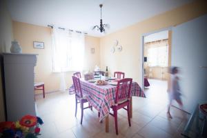 a dining room with a table and chairs and a child running around at Ferme Typique Alsacienne in Truchtersheim