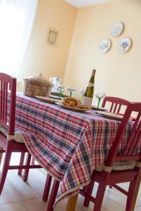 a table with a plaid table cloth and a bottle of wine at Ferme Typique Alsacienne in Truchtersheim