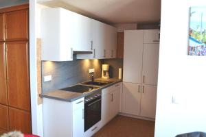 a kitchen with white cabinets and a sink at Ferienwohnung im Strandhotel in Wyk auf Föhr