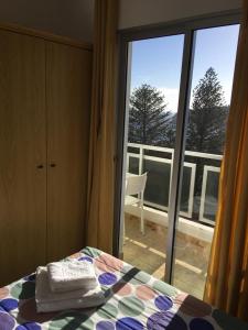 1 dormitorio con 1 cama y vistas a un balcón en Apartamentos Noda, en Playa de Santiago