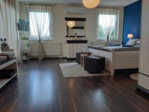 1 dormitorio con 1 cama, paredes azules y suelo de madera en Sonnenoase, en Deutschkreutz