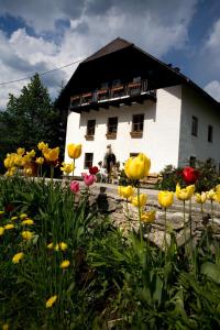 a white building with flowers in front of it at Ferienhof Rotbuchner in Vorderstoder