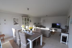 a living room with a dining room table and chairs at Louisiana 1 - Koninklijke Baan 71-B1 in De Haan