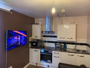 a kitchen with white cabinets and a painting on the wall at Charlesmere gardems in London