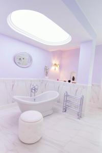 een witte badkamer met een bad en een wastafel bij HB Le suites del Giardino in Taranto