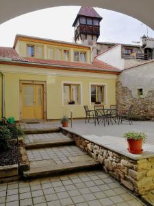 Casa amarilla con patio con mesas y sillas en Apartman U Hippolyta en Jindrichuv Hradec