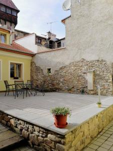 un patio con mesas y sillas y una pared de piedra. en Apartman U Hippolyta en Jindrichuv Hradec