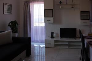 a living room with a couch and a television at BMB Apartments in Senj