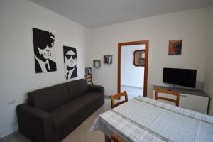 a living room with a couch and a television at MeM House - Tra il Lago di Garda e Verona in Castelnuovo del Garda