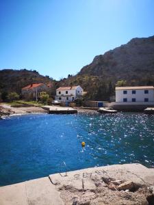a pool of blue water with buildings in the background at Willa Ferry **** in Prizna