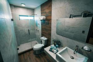 a bathroom with a shower and a toilet and a sink at Hotel Corral Grande in Jamay