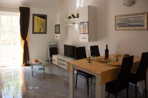a living room with a dining room table with chairs and a television at BMB Apartments in Senj