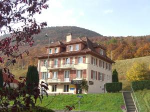 a large house in the middle of a hill at Auberge Pour Tous in Vallorbe