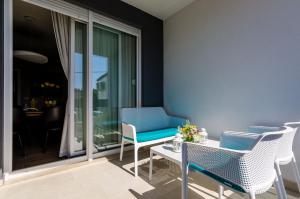 einen Balkon mit einem blauen Stuhl und einem Tisch in der Unterkunft New Art Apartment in Dubrovnik