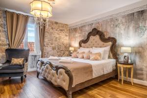 a bedroom with a large bed and a chair at Plaza Marchi Old Town - MAG Quaint & Elegant Boutique Hotels in Split