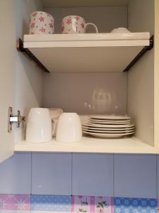 a shelf with plates and cups and dishes on it at Sol y Luz in Isla del Moral