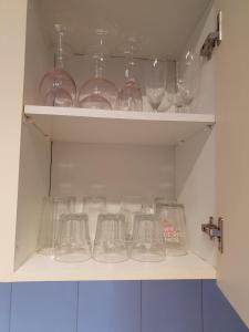 a shelf filled with glass bowls and glasses at Sol y Luz in Isla del Moral