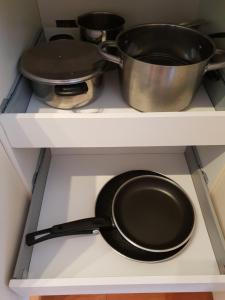 a frying pan and pots on a shelf in a kitchen at Sol y Luz in Isla del Moral