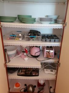 a cupboard filled with dishes and plates at Sol y Luz in Isla del Moral
