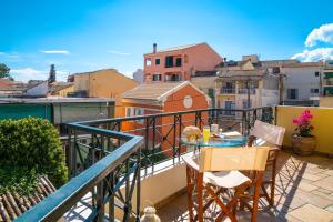 a balcony with a table and chairs on a balcony at Garitsa Maisonette in Corfu