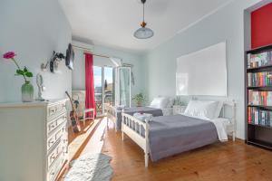 een slaapkamer met een bed en een boekenplank bij Garitsa Maisonette in Corfu-stad