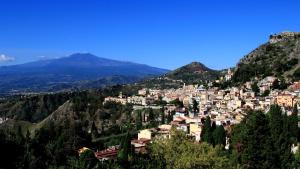 un pueblo en una colina con montañas al fondo en Chloé's Apartment, en Acireale