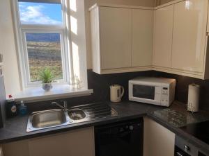 a kitchen with a sink and a microwave at Broadsea in Inverurie