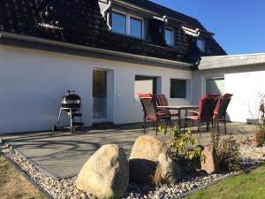 un patio con mesa, sillas y parrilla en Ferienhaus BAUMBLÜTE, en Werder