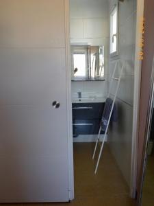 La salle de bains est pourvue d'un lavabo, d'un miroir et d'une porte. dans l'établissement Les pieds dans l'eau : grand T2 avec garage, à La Ciotat