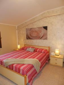 1 dormitorio con 1 cama y una pintura en la pared en RUSTICO PARK DELLE ROSE - Regarda Travel, en Lazise