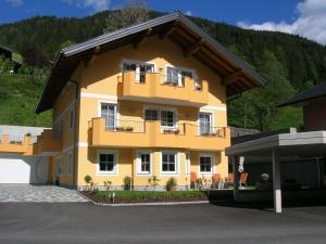 a yellow house with a balcony on the side of it at Maria's Platzl Wagrain in Wagrain
