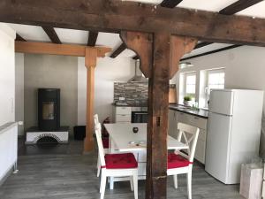 a kitchen with a table and chairs and a refrigerator at Apartment im Schwarzwaldhaus in Schluchsee