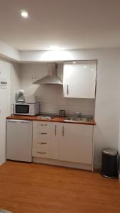 a kitchen with white cabinets and a sink and a microwave at Apartment Plaza Del Salvador in Seville