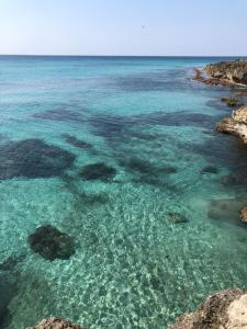 a view of the clear blue ocean with rocks at B&B Anirè in Taranto