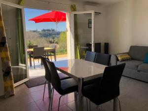 a living room with a table and a red umbrella at Résidence Château Saint Martin in Saint-Martin-dʼArdèche