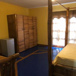a bedroom with a bed and a dresser and a window at La Cueva del Che in Juan Dolio