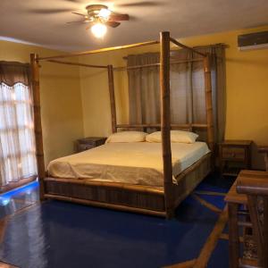 Un dormitorio con una cama con dosel en una habitación en La Cueva del Che, en Juan Dolio