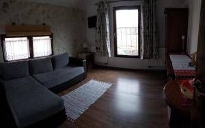 a living room with a couch and two windows at Pensiunea Casa Dacilor in Podeni +196 photos