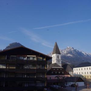 a building with a church with a mountain in the background at Ferienwohnung Klein&Fein in Bad Aussee