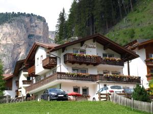 a building with cars parked in front of it at Garni Flurida in Selva di Val Gardena