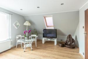 a living room with a table and a tv at Apartament Joanna in Tolkmicko