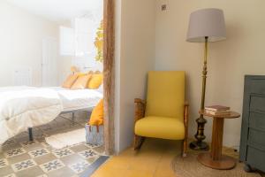 a bedroom with a bed and a yellow chair at Bendita Casa in Granada